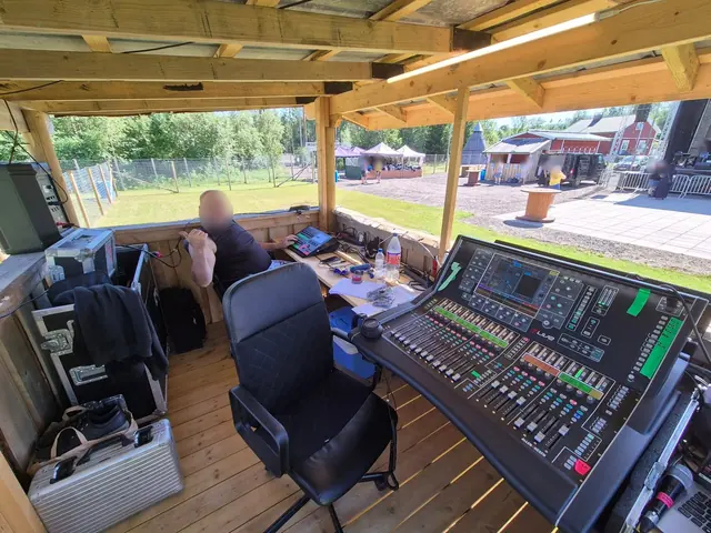 Ljudteknikern i ljudtornet med mixerbord och utsikt över festivalområdet.