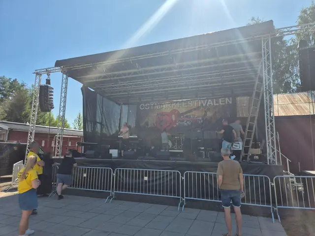 Publik och crew vid scenkanten under soundcheck i eftermiddagssolen.